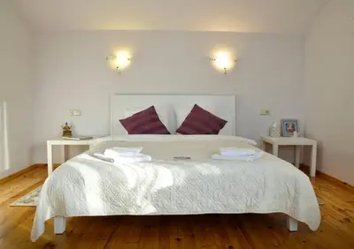 a bedroom with a large white bed with two tables at Irena Family House in Vilnius