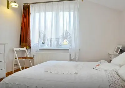 a bedroom with a white bed and a window at Irena Family House in Vilnius
