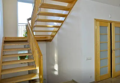 a wooden staircase in a room with a door at Irena Family House in Vilnius