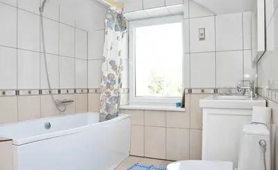a bathroom with a tub and a toilet and a window at Irena Family House in Vilnius
