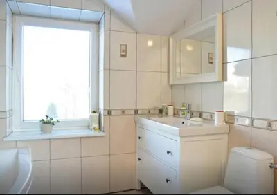 a bathroom with a sink and a toilet and a window at Irena Family House in Vilnius