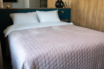 a large bed with white sheets and pillows at Four Sisters Luxury Rooms in Siauliai in Šiauliai