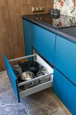 a kitchen with a blue cabinet with pots and pans at Four Sisters Luxury Rooms in Siauliai in Šiauliai