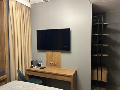 a hotel room with a television on a wall at Four Sisters Luxury Rooms in Siauliai in Šiauliai