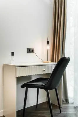 a black chair sitting in front of a desk at Riverra House - Two-bedroom Apartment in Kaunas