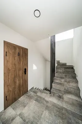 a hallway with stairs and a wooden door at Riverra House - Two-bedroom Apartment in Kaunas