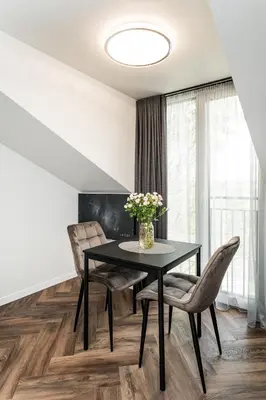 a dining room with a black table and chairs at Riverra House - Studio Panorama View in Kaunas