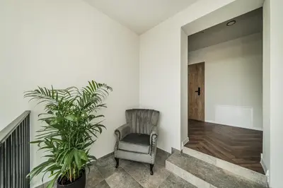 a hallway with a chair and a potted plant at Riverra House - Studio Panorama View in Kaunas