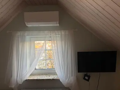 a window with a white curtain and a tv at Trakų Namelis in Trakai