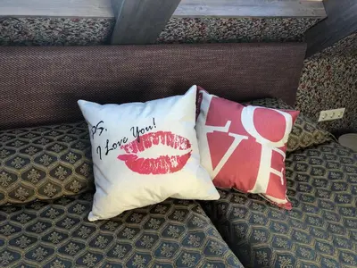 two pillows on a bed with a mouth on them at Medžiotojų Sostinė in Kunioniai