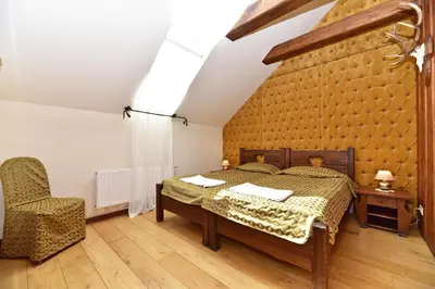 a bedroom with a bed and a chair at Medžiotojų Sostinė in Kunioniai