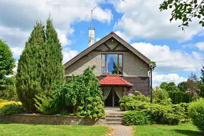 a house with a cross on the roof at Medžiotojų Sostinė in Kunioniai
