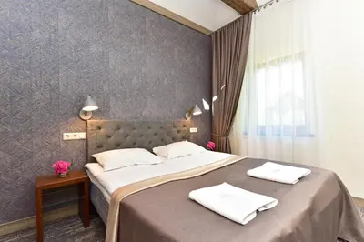 a bedroom with a large bed with white towels on it at Medžiotojų Sostinė in Kunioniai