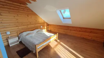 a bedroom with a bed in a room with wooden walls at Prie Galvės in Trakai