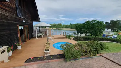 a wooden deck with a table and an umbrella at Prie Galvės in Trakai
