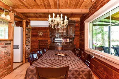 a dining room with a table and chairs and a chandelier at Vila Loreta - visas privatus namas in Dūdorynė
