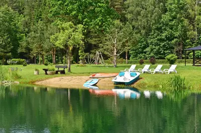 a group of boats sitting on the shore of a lake at Vila Loreta - visas privatus namas in Dūdorynė