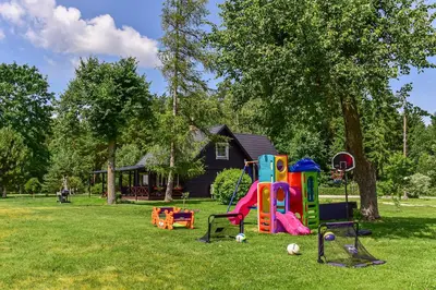 a group of playground equipment in a yard with a house at Vila Loreta - visas privatus namas in Dūdorynė