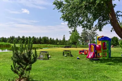 a park with two play equipment in the grass at Vila Loreta - visas privatus namas in Dūdorynė
