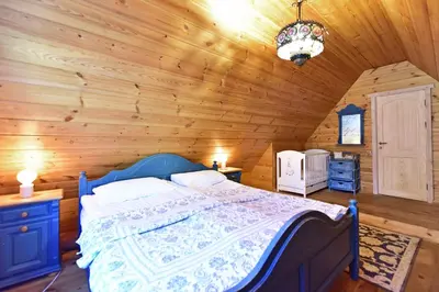 a bedroom with a bed in a wooden room at Vila Loreta - visas privatus namas in Dūdorynė