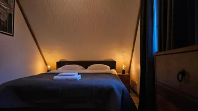 a bedroom with a bed with two towels on it at 4 Wheels Cabin in Būda