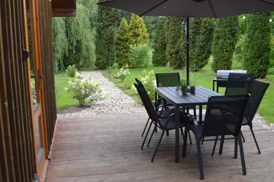 a table and chairs with an umbrella on a patio at 4 Wheels Cabin in Būda