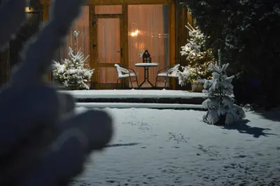 a porch with a table and chairs in the snow at 4 Wheels Cabin in Būda