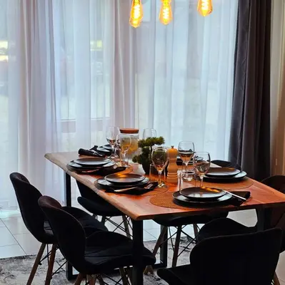 a wooden table with chairs and wine glasses on it at 4 Wheels Cabin in Būda