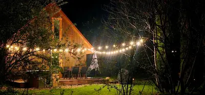 a house with christmas lights on it at night at 4 Wheels Cabin in Būda