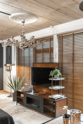 a living room with a television and a chandelier at Barber Apartment in Kaunas