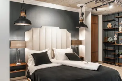 a bedroom with a large bed with black and white pillows at Barber Apartment in Kaunas