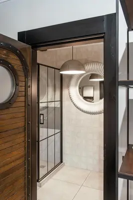 a bathroom with a mirror and a circular light at Barber Apartment in Kaunas