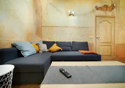 a living room with a blue couch with a remote control at Old Town Apartments FREE Parking in Vilnius
