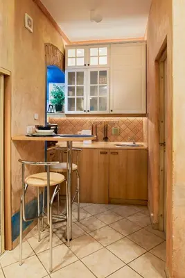 a kitchen with wooden cabinets and a table and chairs at Old Town Apartments FREE Parking in Vilnius