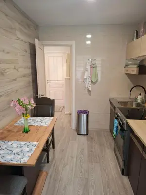 a small kitchen with a table and a sink at Apartamentai Auris in Druskininkai