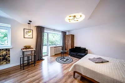 a bedroom with a bed and a couch in a room at Hugo apartment in Šiauliai