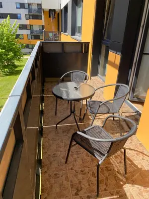a patio with two chairs and a table on a balcony at Vita apartment in Vilnius