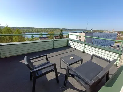 a patio with two chairs and a table on a roof at viešbutis Jurbarkas in Jurbarkas