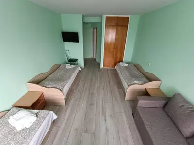 a room with two beds and a couch in it at viešbutis Jurbarkas in Jurbarkas