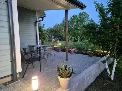 a patio with a table and chairs on a house at Namas Zarasuose su vyno rūsiu in Zarasai