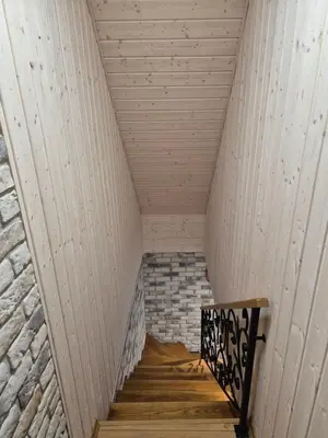 a staircase in a room with a white ceiling at Namas Zarasuose su vyno rūsiu in Zarasai