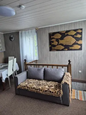a living room with a bed and a dining table at Dariaus ir Gireno 7 in Zarasai