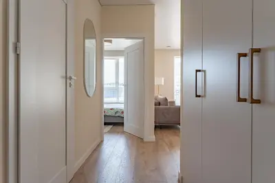 a hallway with white walls and a mirror in a room at Cozy apartment with huge terrace in Vilnius