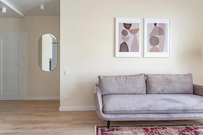 a living room with a couch and a mirror at Cozy apartment with huge terrace in Vilnius