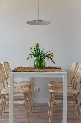 a dining room table with a vase of flowers on it at Cozy apartment with huge terrace in Vilnius