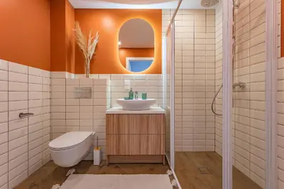 a bathroom with a toilet sink and a mirror at Cozy apartment with huge terrace in Vilnius