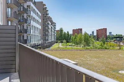 a balcony of a apartment building with a grass field at Cozy apartment with huge terrace in Vilnius