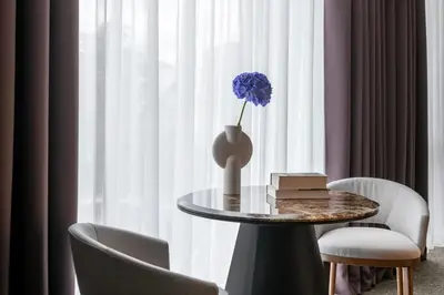 a table with a vase with a blue flower on it at Harmony Birštonas in Birštonas