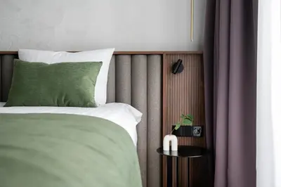 a bedroom with a bed with a green pillow at Harmony Birštonas in Birštonas