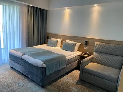a hotel room with a bed and a chair at Molėtai Hotel in Molėtai